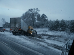 snowy conditions cause semi-truck to jack-knife in the highway