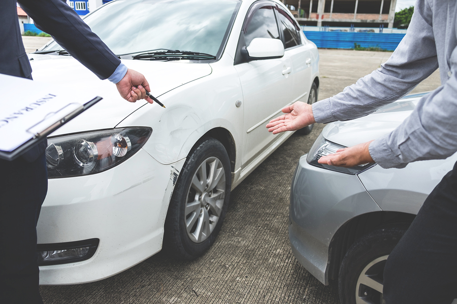 Insurance adjuster looking at car accident damage