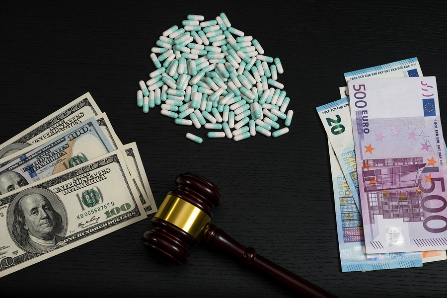 Money and pills with gavel on a tabel