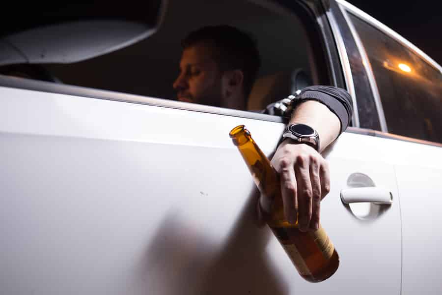 Man driving with an alcoholic beverage