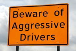 orange road sign that says "Beware of Aggressive Drivers"