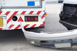 bumper that has fallen off of a white vehicle after an auto accident