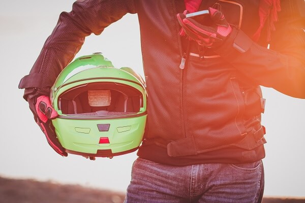 motorcycle rider holding helmet to the side