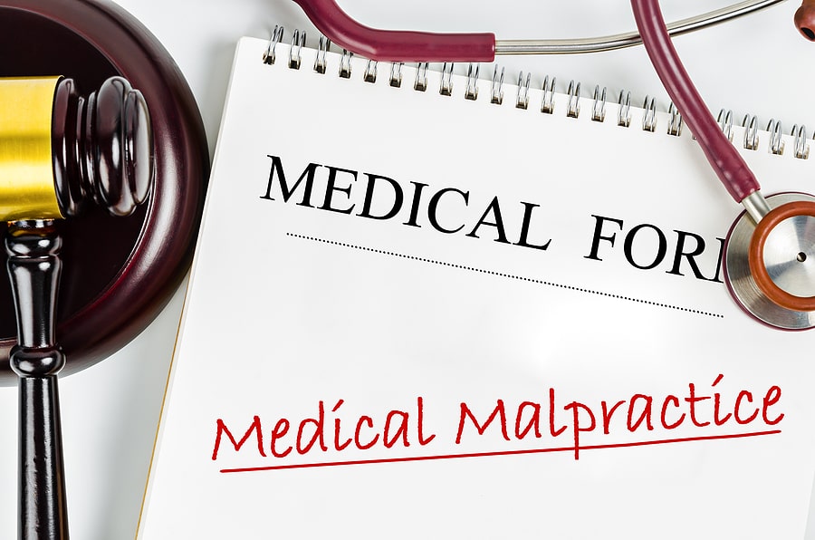 Medical malpractice written on a notepad