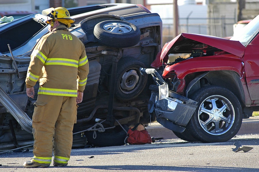 firefighter standing next to a multi-vehicle collision