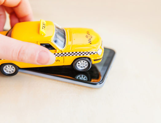 Toy taxi on top of a smartphone