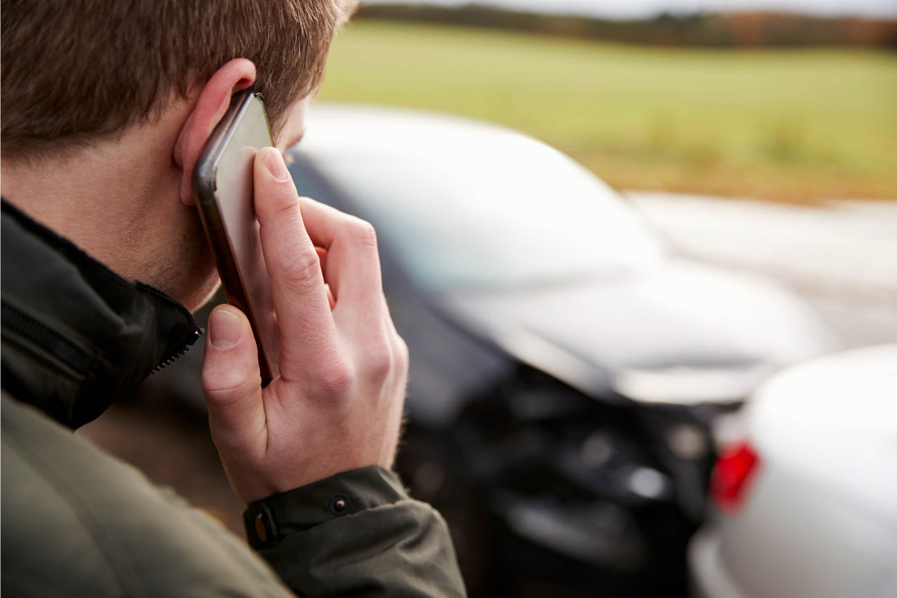 Man making a phone call after a car accident