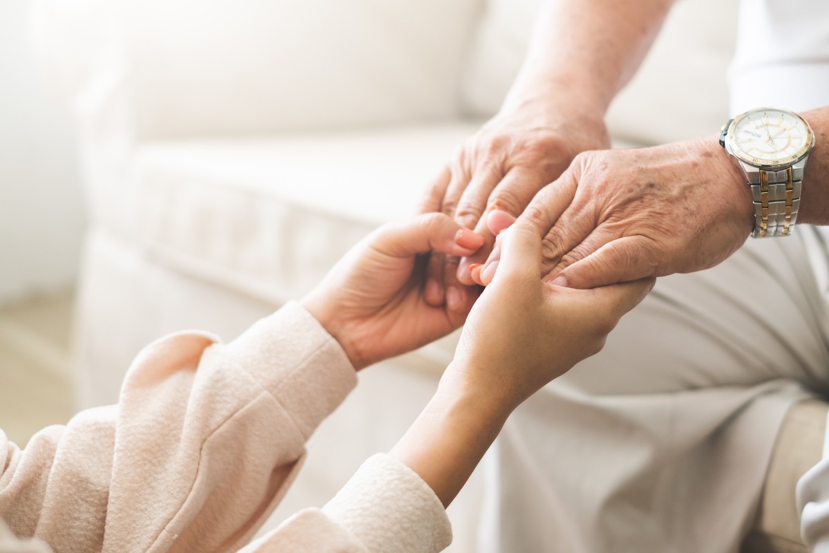 Woman holding an elderly man's hands