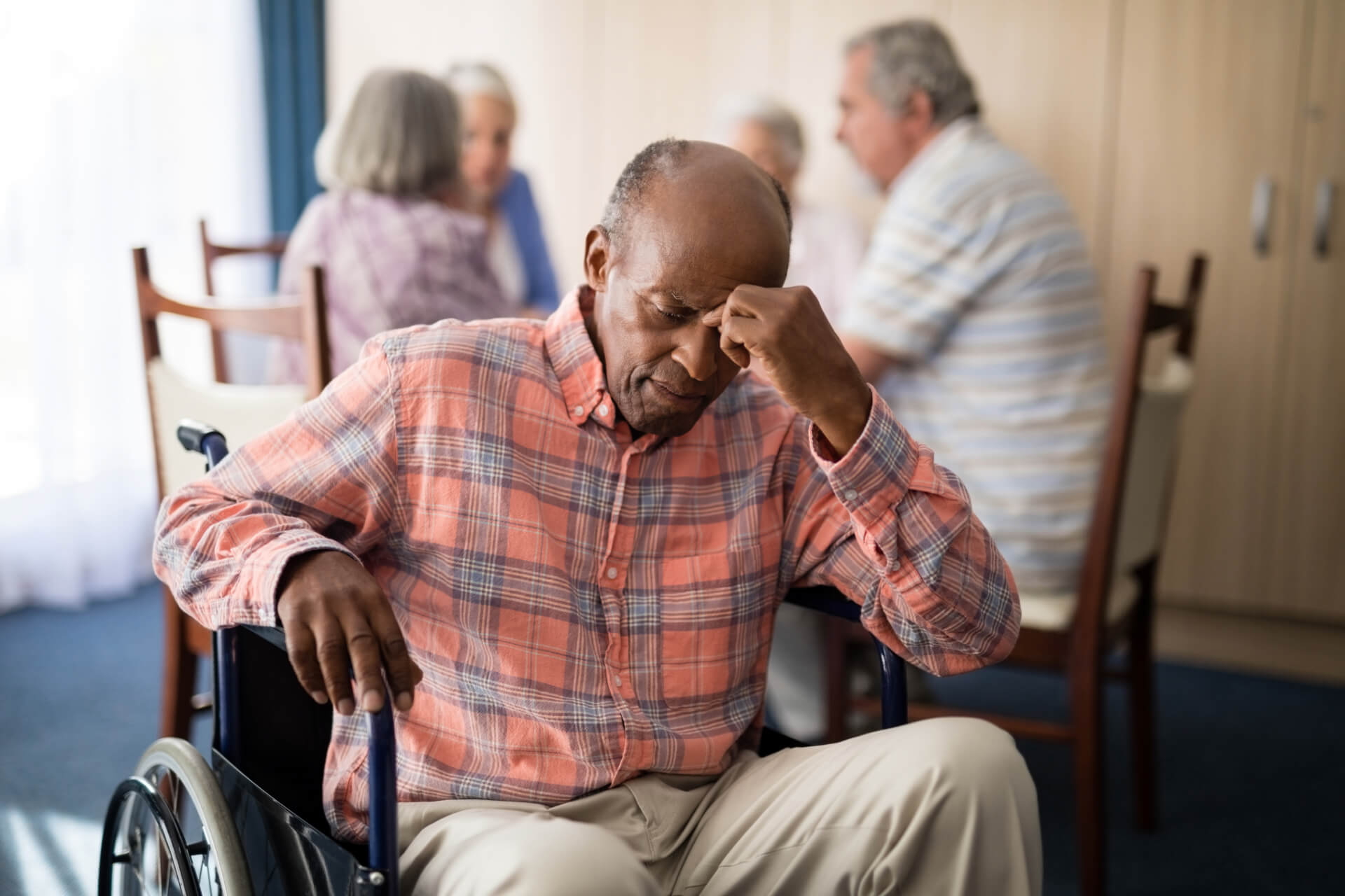 depressed disabled senior man sitting on wheelchair