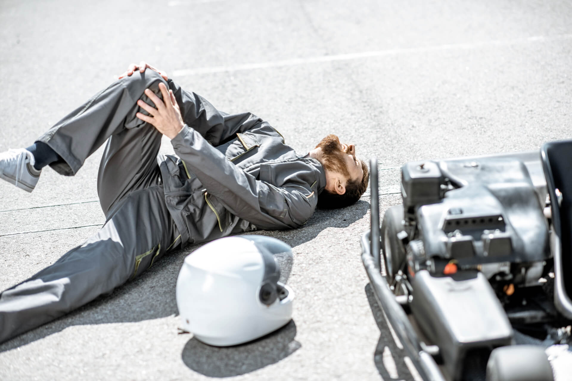 motorbike rider crashed on the road holding his knee