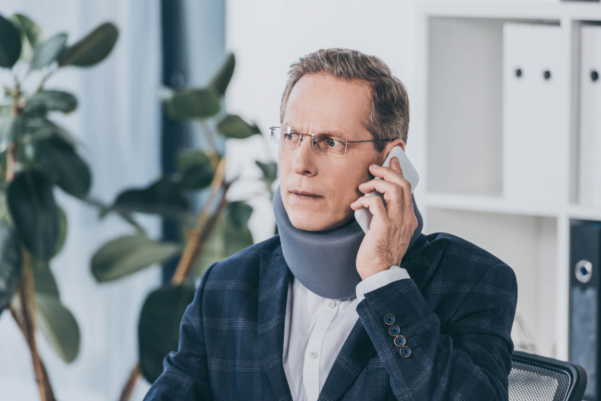 injured man with a neck brace on calling a personal injury lawyer