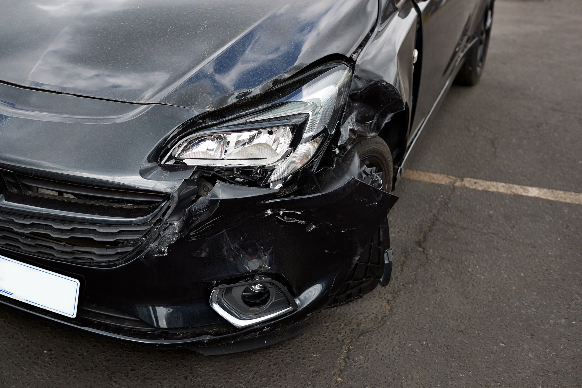 Front view of car with visible headlight and bumper damage