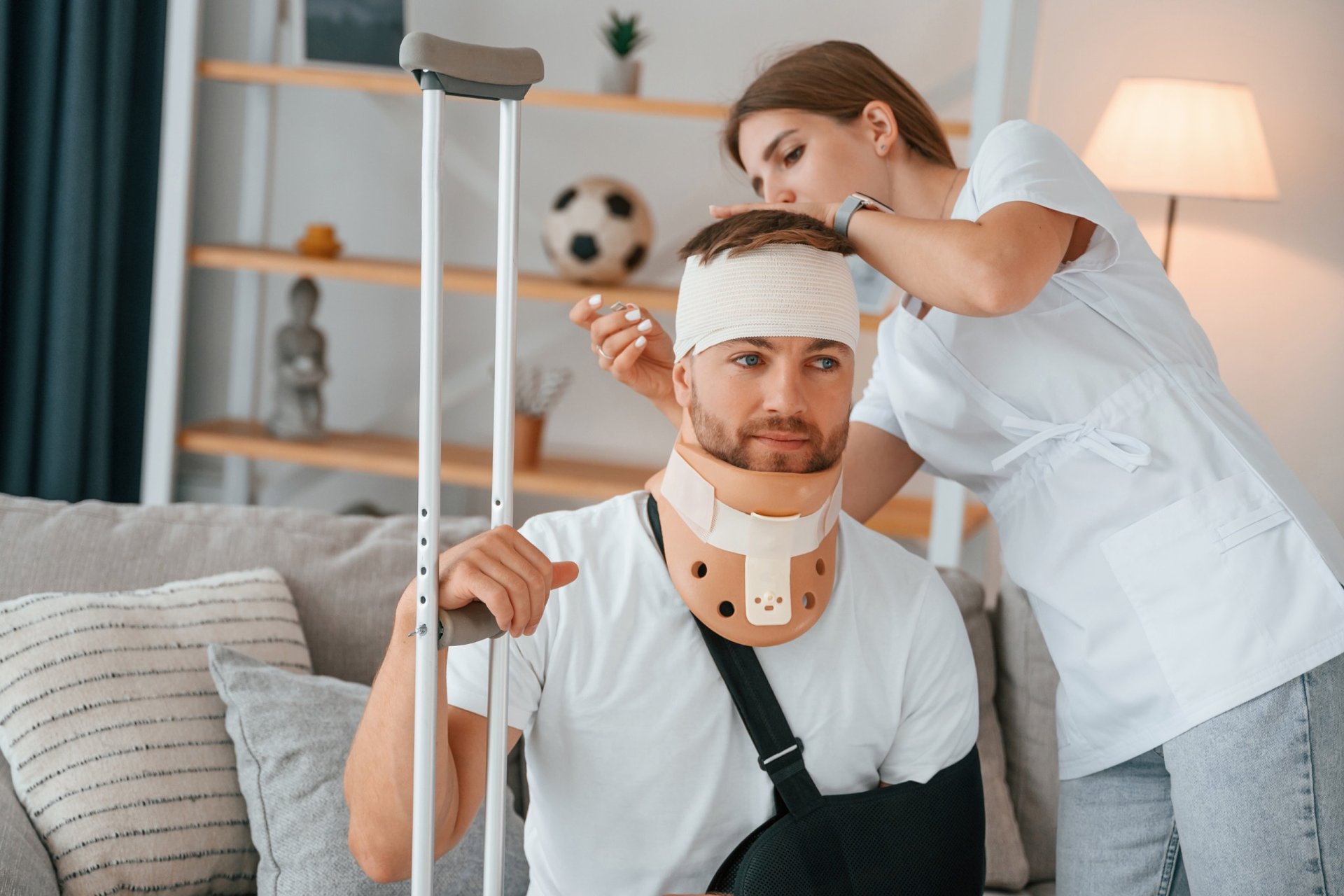 Nurse caring for an injured man wearing a neck brace and arm sling