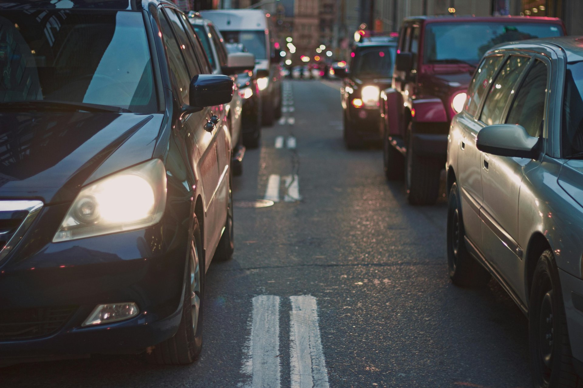 Congested urban street with cars and headlights during rush hour